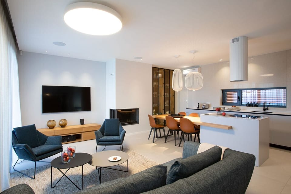 Modern living room with LCD TV and fireplace and equipped kitchen with kitchen island and chairs for 6 people