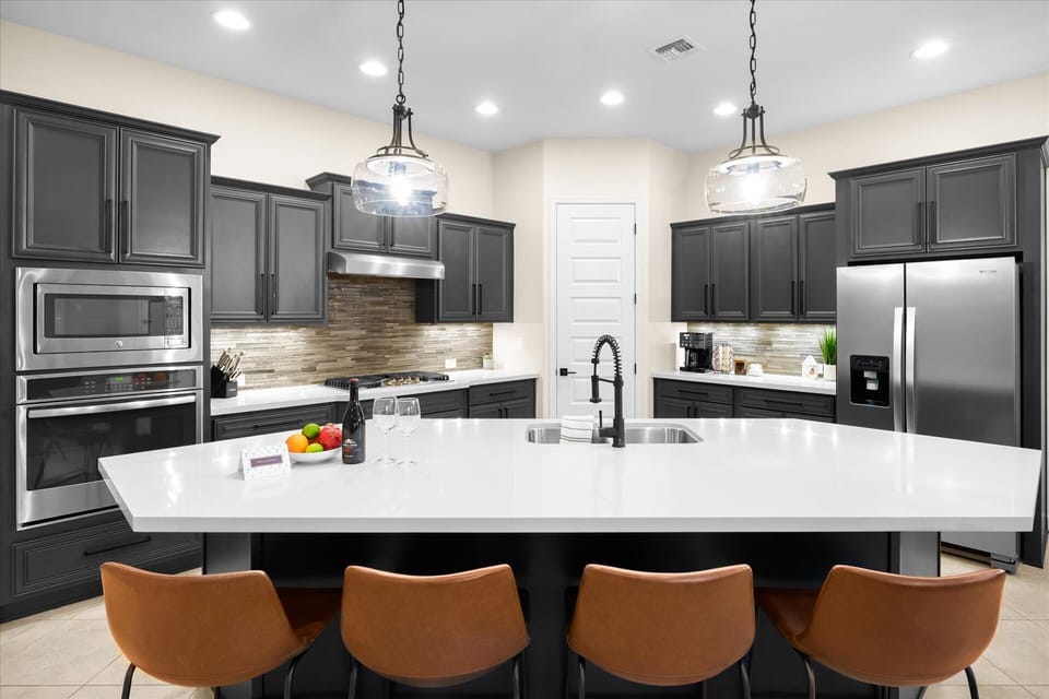 Kitchen | Fully Equipped with High-End Appliances Prepare meals in this sleek kitchen with a gas range, large island, and all essentials.