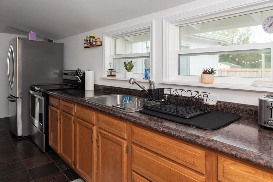 Kitchen with pots, pans, plates, glasses, wine glasses, microwave & more. 