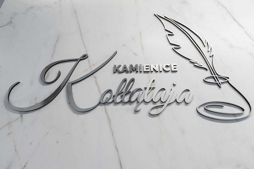 A close-up of the building's name or logo engraved on a marble plaque.
