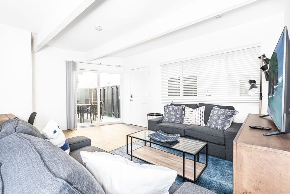 Clean with crisp white touches, the main living area features 2 sofas and a streaming TV.
                