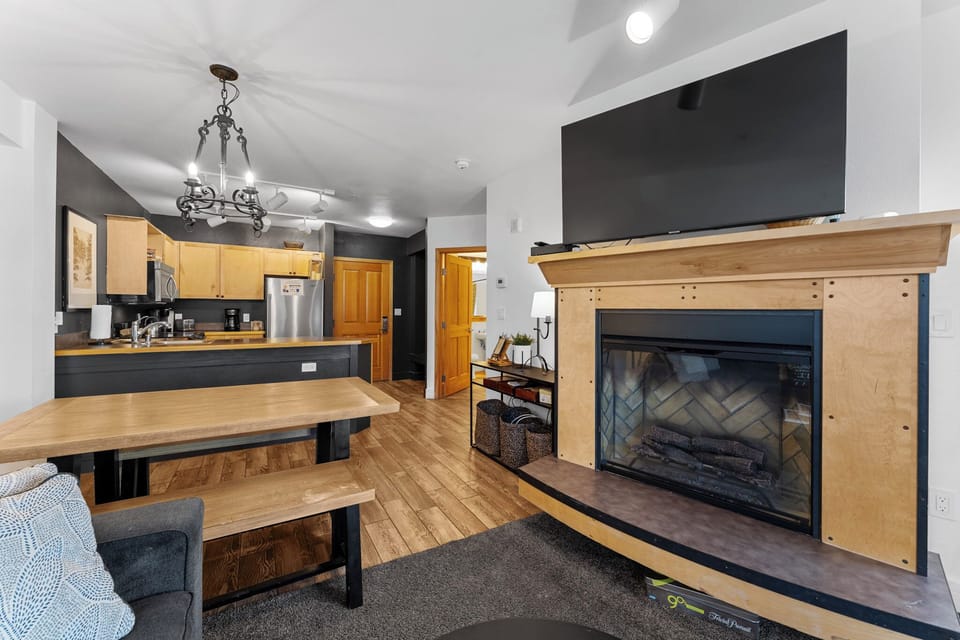 Cozy up by your fireplace while enjoying the open-concept kitchen and dining space, complete with modern amenities and rustic wood touches.