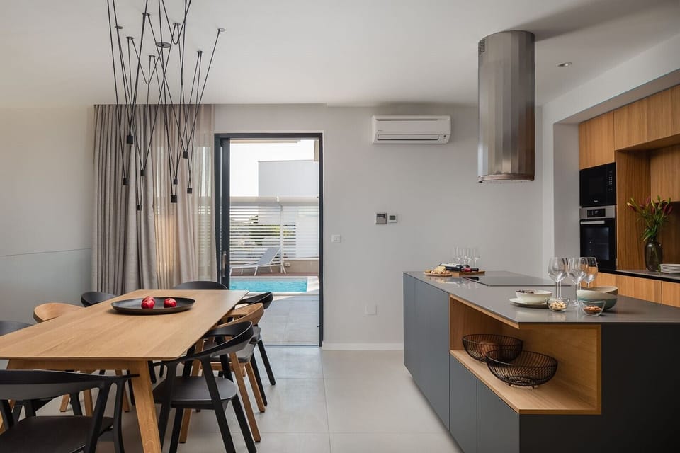 Kitchen and dining table next to which there is a door to the outdoor terrace of the luxury villa with Murter Glory