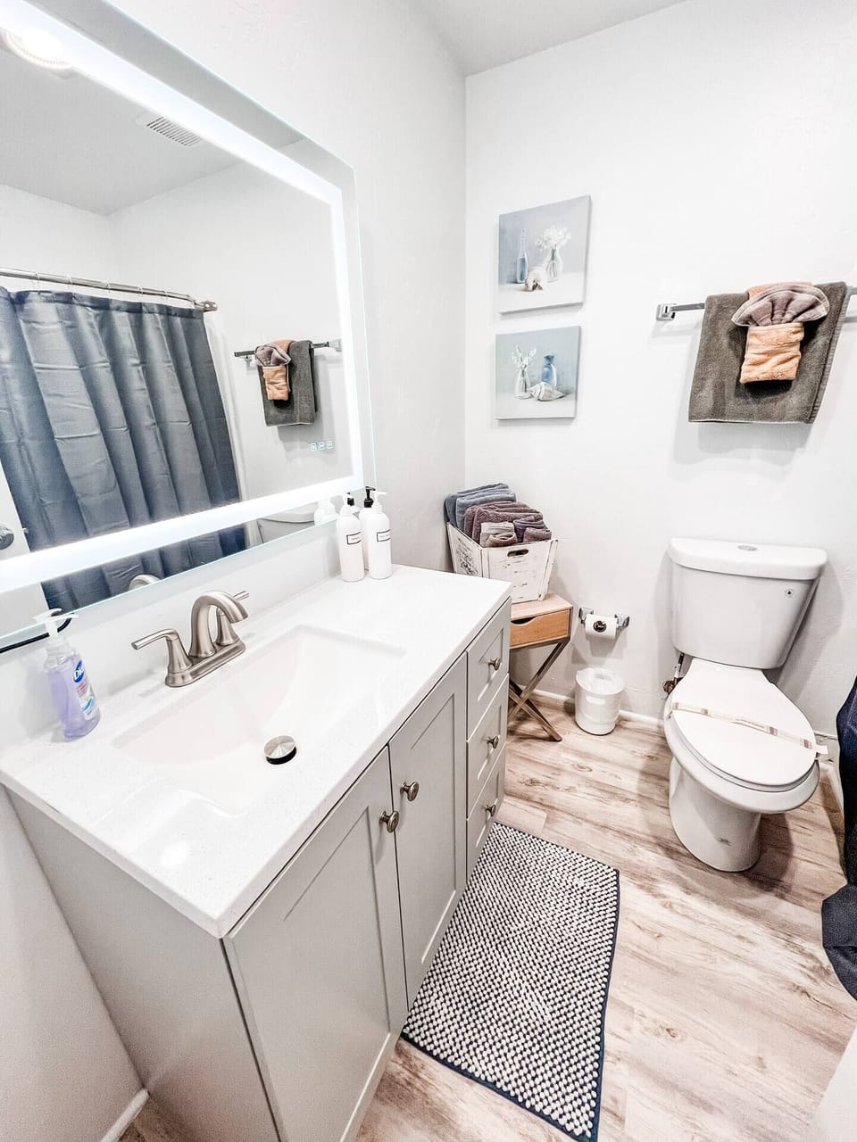 A Remodeled Full Restroom with a hair dryer, shampoo, body wash, towels, toilet paper and conditioner