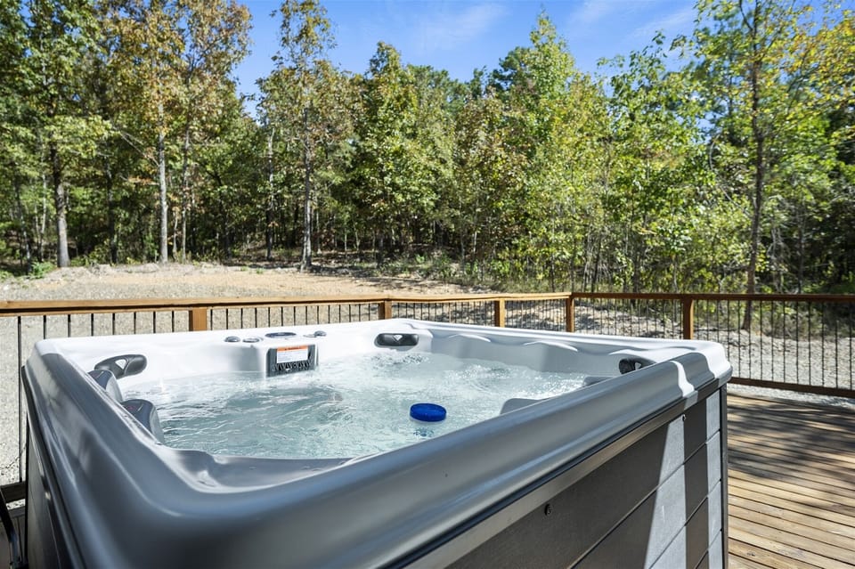 Hot Tub Oasis: Relax in the bubbling waters with a scenic forest backdrop!