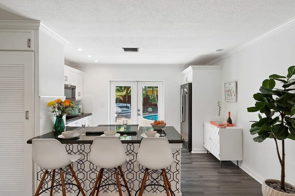 HAVE A QUICK SEAT OR MEAL IN THE BAR SEATING OVERLOOKING THE KITCHEN AND POOL AREA