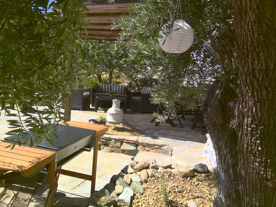 Shaded terrace with furniture and BBQ.
