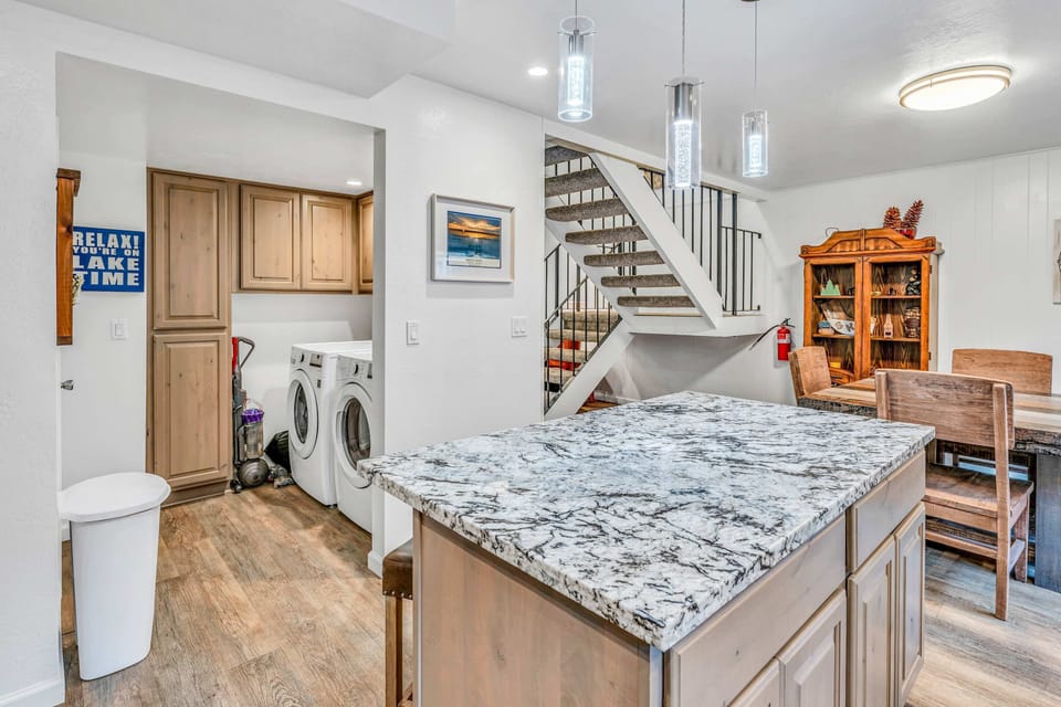 he kitchen flows directly into the laundry space, making it easy to keep up with clothes and linens during longer stays.