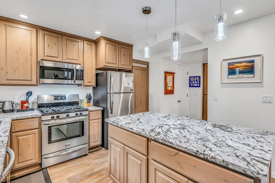 Sleek kitchen with stone counters and stainless steel appliances, ready for your favorite recipes.