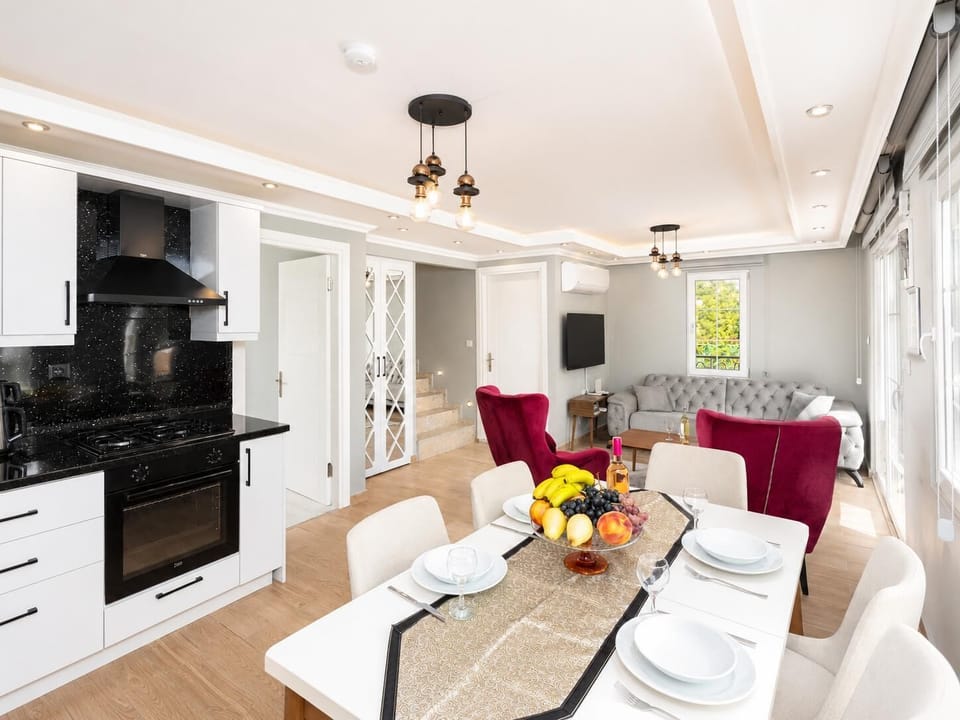 Open-plan living room with sofa, dining area, kitchen, A/C, WiFi internet, and satellite TV