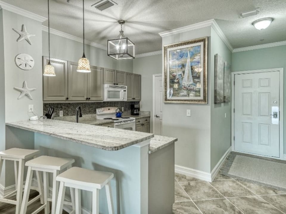 Your fully equipped kitchen awaits with granite counters, coastal charm, and everything needed to create memorable meals during your stay.