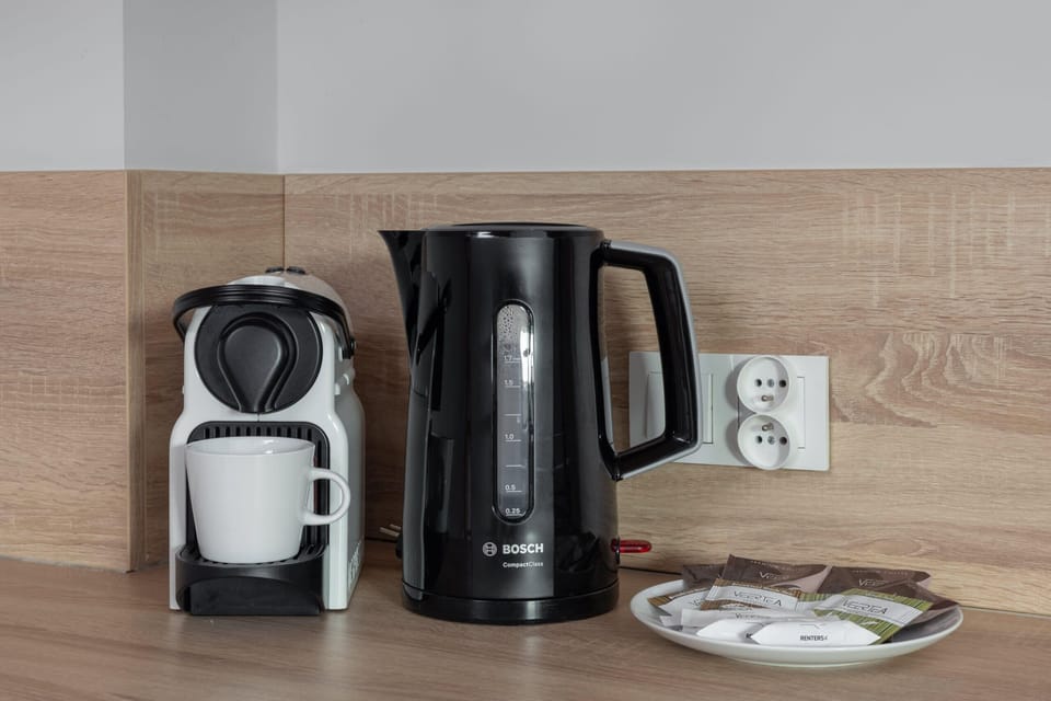 A detailed view of the kitchen counter featuring a coffee machine, kettle, and other appliances.
