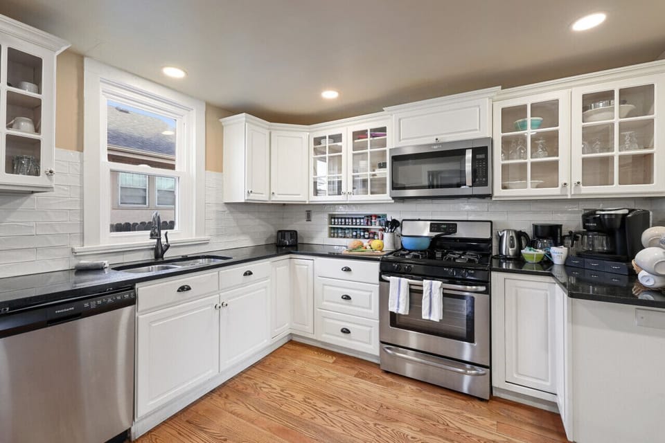 Kitchen fully stocked with cookware, serving ware, spices and other staples