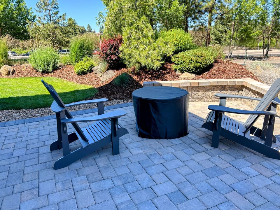 Firepit and patio with views of mountains, the river, and Old Mill Smokestacks.