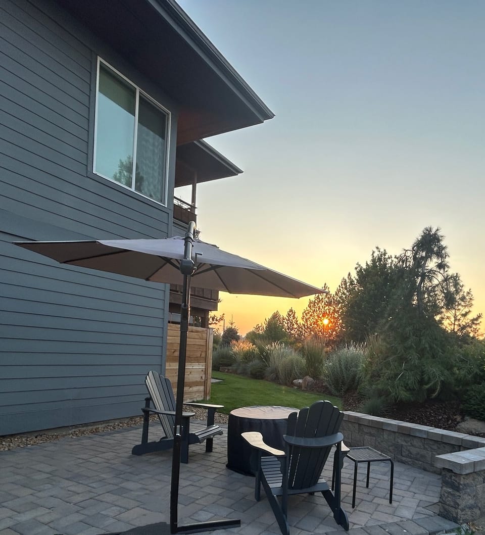 Firepit and patio with views of mountains, the river, and Old Mill Smokestacks.