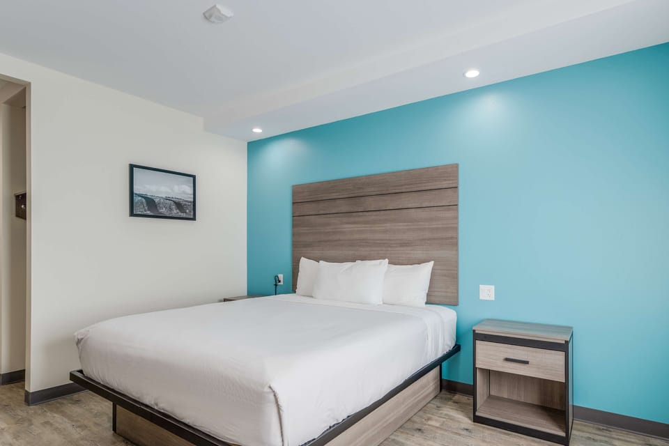 Unwind in a crisp king bed with calming teal accents.