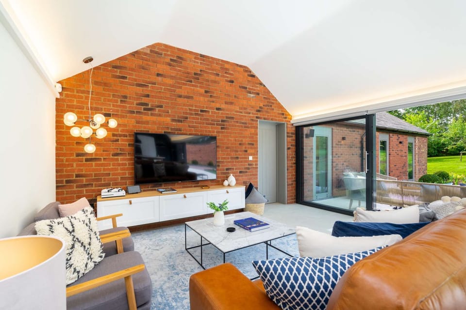 The sitting room area, with its feature brick wall, is a warm and cosy area to relax and enjoy time together and reconnec