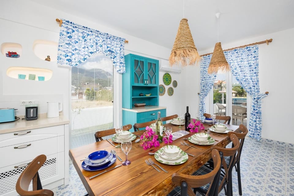 Open-plan living room with sofa, dining area, kitchen, A/C, WiFi internet, and satellite TV