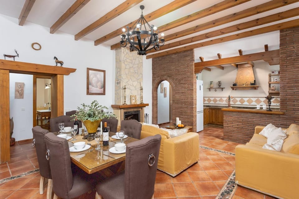 Open-plan living room with sofas, dining area, kitchen, ornamental fireplace, A/C, WiFi internet, satellite TV, and sea views
