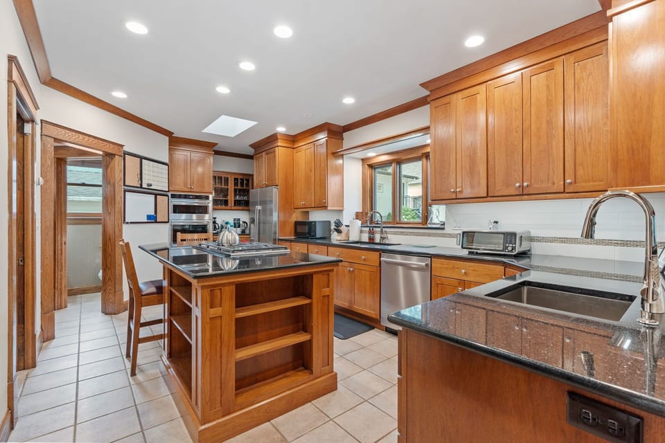Your gourmet kitchen features rich wood cabinetry, granite counters, and a spacious island perfect for cooking memorable meals.