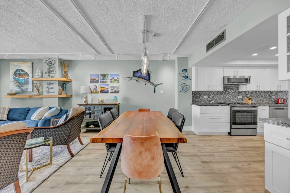 Picture yourself gathering around this beautiful live-edge dining table, sharing meals in your open-concept retreat with a fully equipped kitchen, cozy living space, and coastal-inspired decor that instantly feels like home.