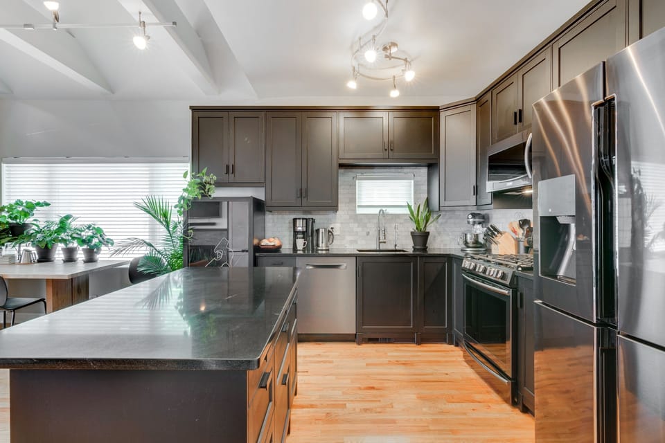 Black granite countertops and a marble backsplash provide a beautiful backdrop for your culinary creations. This well-equipped gourmet kitchen will delight your inner Top Chef.
