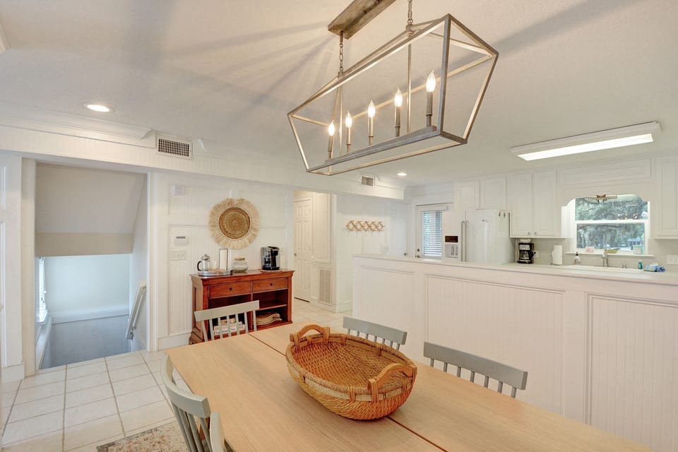 Kitchen & Dining – St. Simons Vacation Rental with Coffee Statio - Light and open dining area with a full kitchen, coffee station, and seating for six—perfect for pancake breakfasts or post-beach takeout. Bright, white finishes and coastal touches bring the island charm inside.