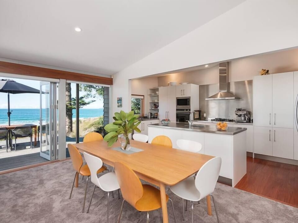 Spacious open plan living offers a sleek modern kitchen with central island and window with leaner and a comfortable dining area