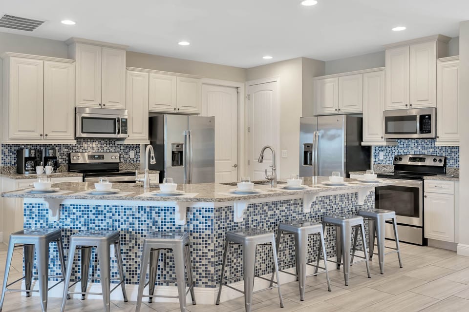 Kitchen area w/ large island and stainless-steel appliances
