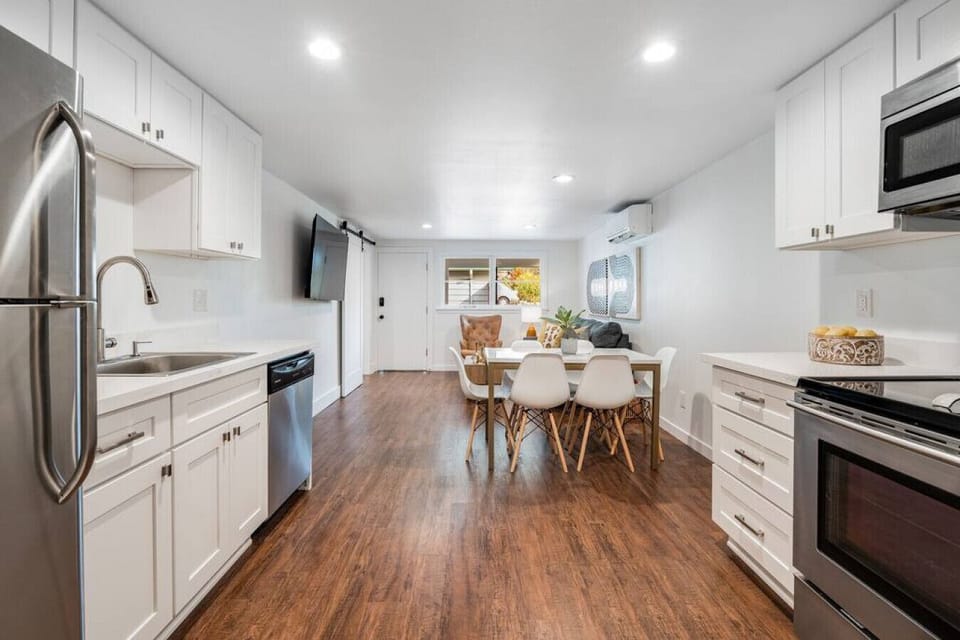 Fully stocked kitchen near dining and living areas with AC and TV.