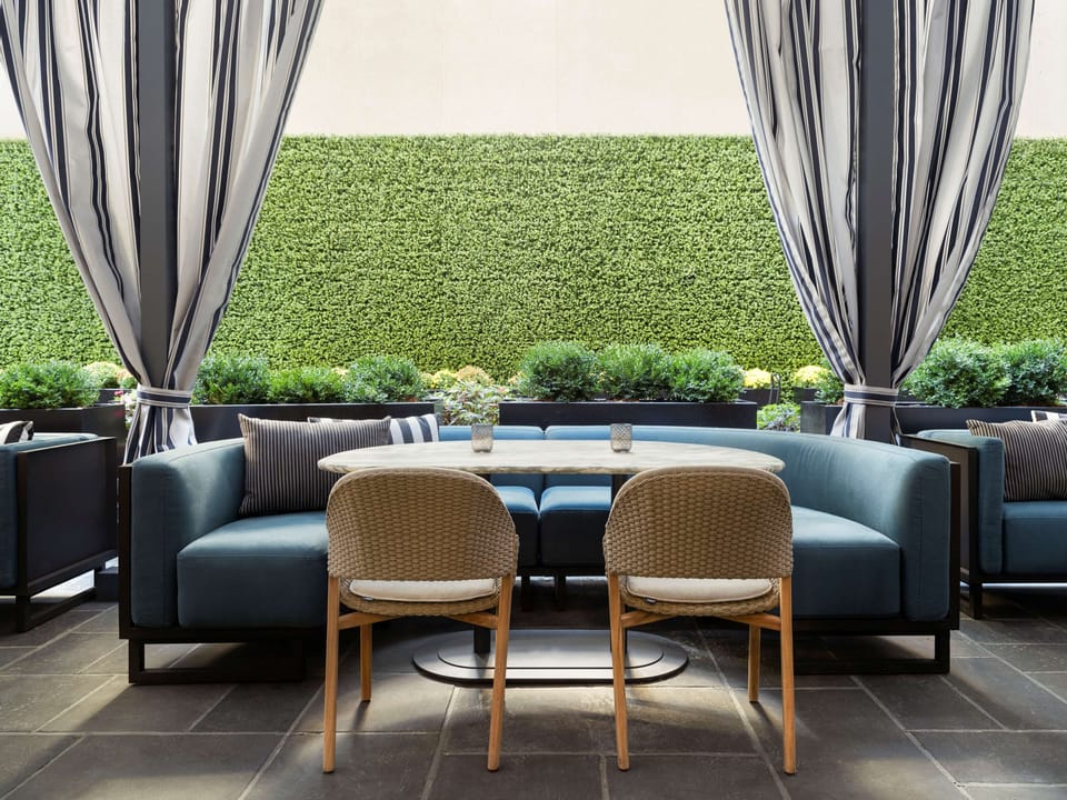 Unwind outdoors with cushioned seating and breezy privacy curtains.