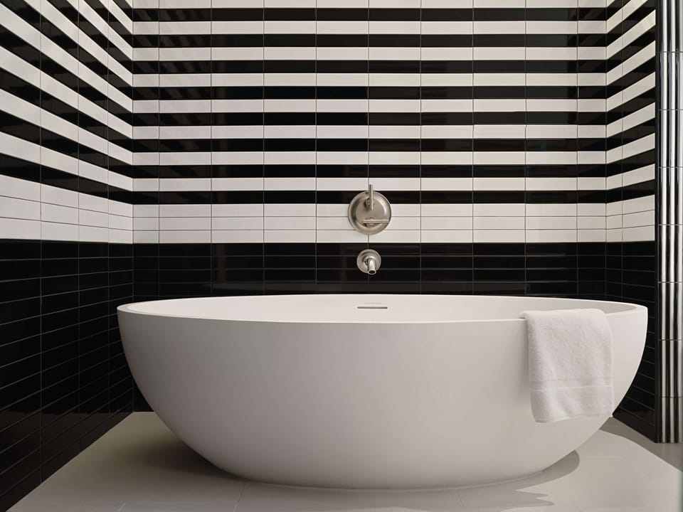 Soak peacefully in the deep tub beneath bold tile lines.
