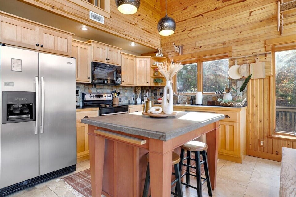 Between the dining and kitchen areas is a large island with two barstools.
