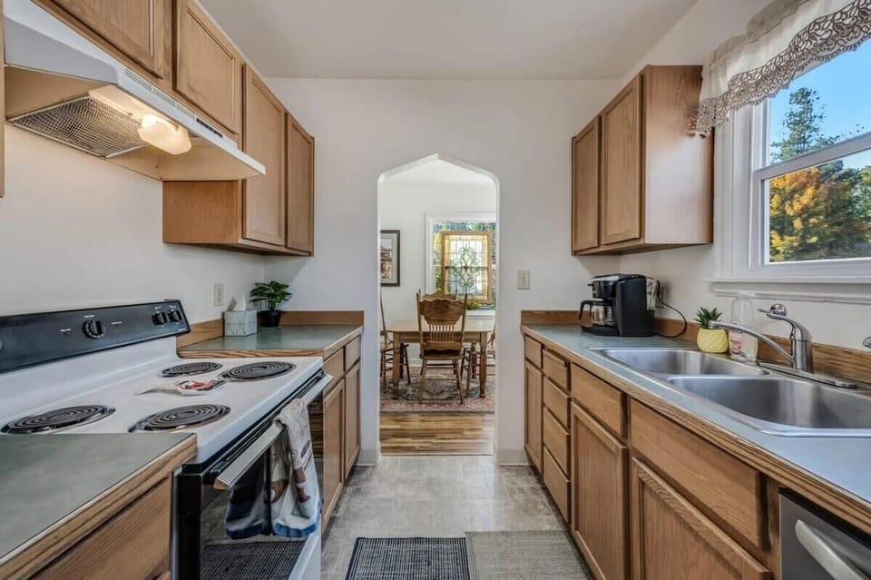Your fully equipped kitchen flows into a charming dining area, perfect for preparing home-cooked meals and enjoying views of the surrounding autumn foliage.