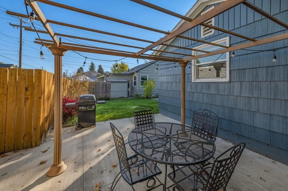Your covered patio invites outdoor dining with string lights creating ambiance and BBQ grill ready for memorable meals together.