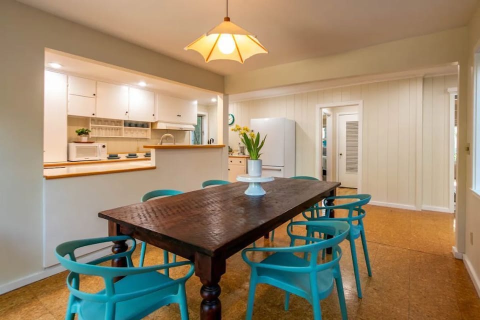 Six chairs and large dining room table in dining room.