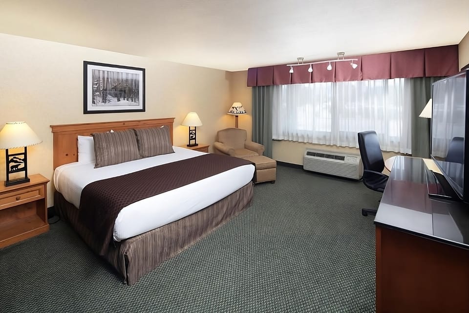 Sink into a plush king bed beside a relaxing armchair.
