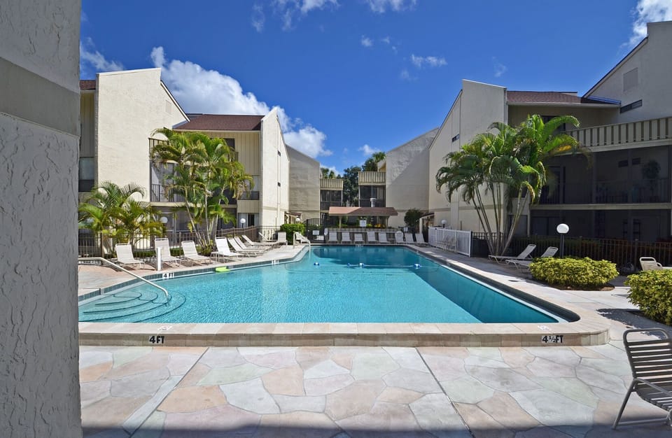 Bay Oaks community building exterior and resort-style swimming pool with lounge area