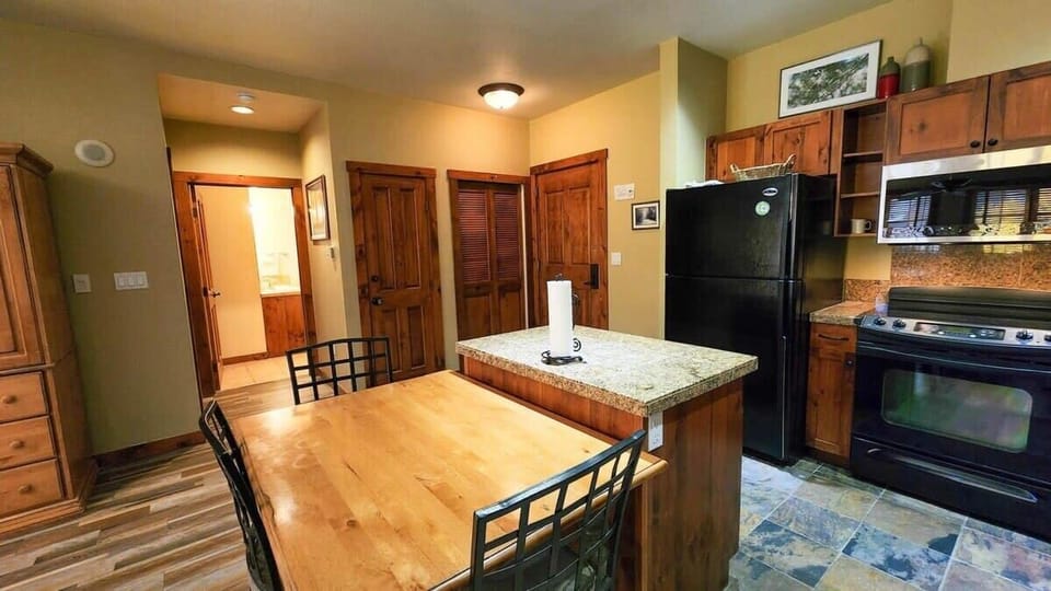 The kitchen provides a dining table with seating up to 6. Just off the kitchen area is the hallway to the full bathroom and master bedroom.