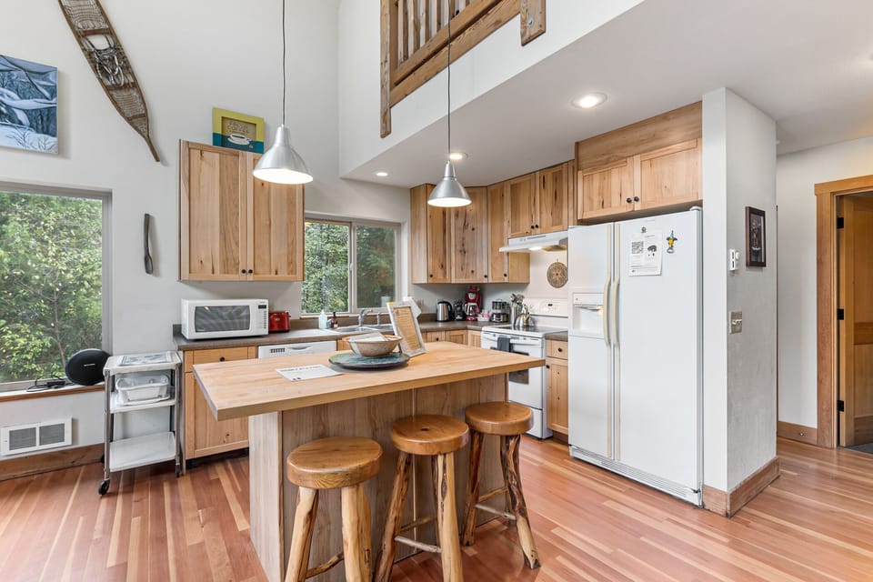 Fully stocked kitchen with appliances including a dishwasher. Door & stairs to basement level is just out of frame to the right
