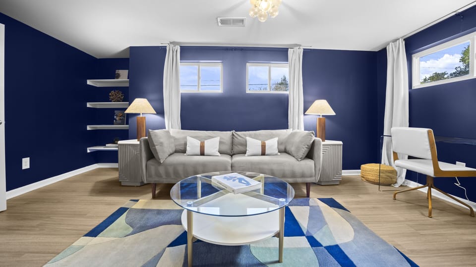 Living space, featuring vibrant navy walls, modern furnishings.