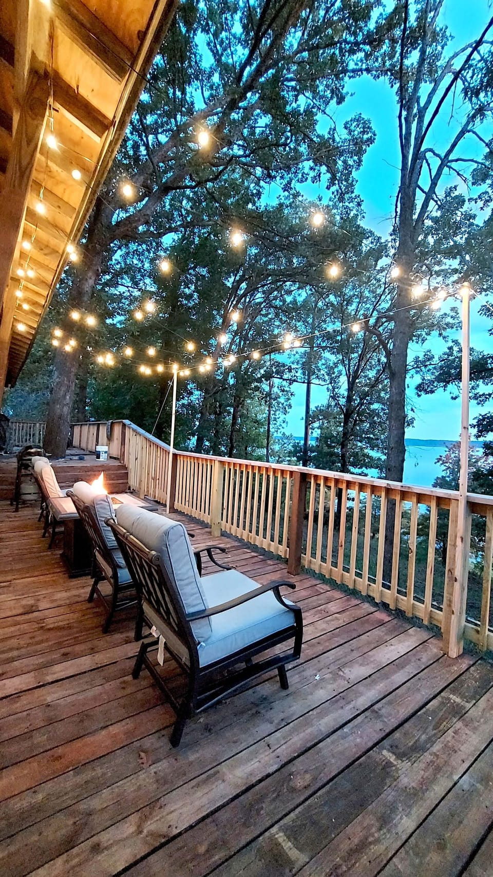 Back deck with string lights, fire pit, and propane grill