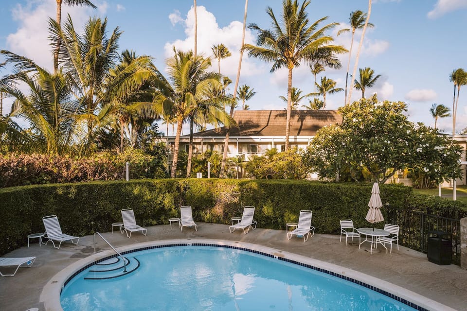 Unwind on sun loungers beside a sparkling tropical pool.