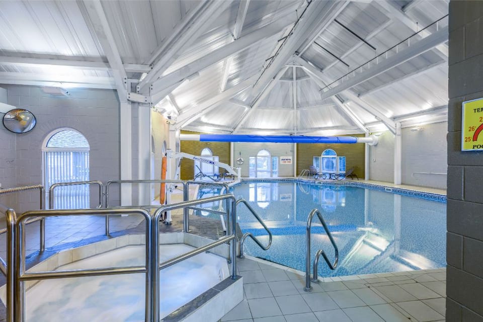 A view of the pool with a ramp, emphasizing the facility's accessibility for all guests.