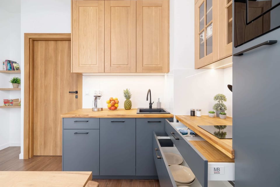 A kitchen with a modern and rustic blend, featuring blue cabinets and wooden accents.
