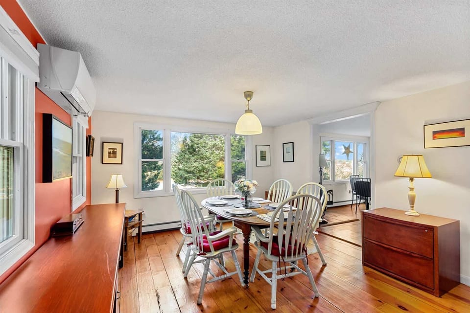 Another view of the dining room featuring a large picture window that fills the space with Cape Cod light.