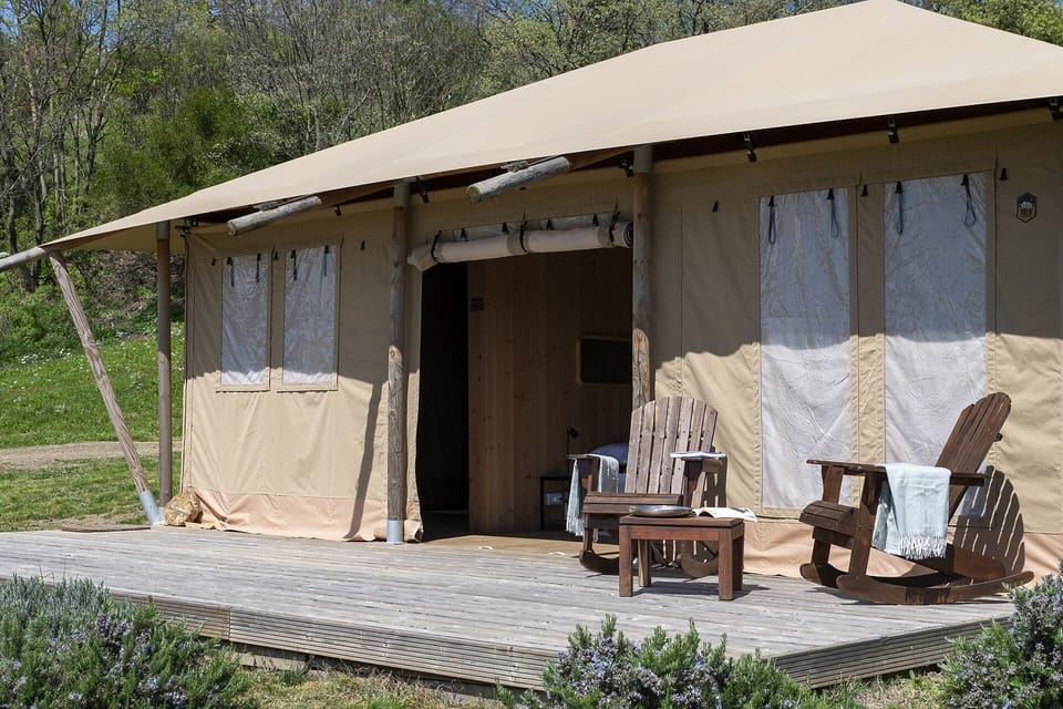 Entrance of the Stardust Lodge defined by refined architecture and premium materials. Natural wood structures, a spacious panoramic deck, and solid wood seating embody elevated rustic elegance. Every element—from durable canvas textures to handcrafted finishes—reflects understated luxury immersed in the wilderness.