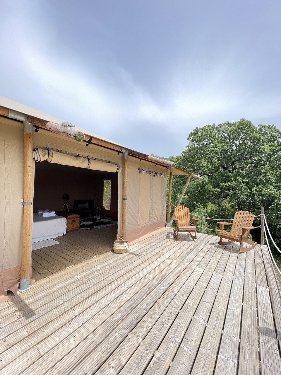 Safari-style luxury lodge featuring a spacious panoramic terrace immersed in nature. The expansive wooden deck, with forest-view chairs, sets the stage for romantic sunsets, while the inviting interiors blend charm with exclusive comfort. Perfect for a couples’ getaway or a luxury wilderness retreat surrounded by privacy, tranquility, and unspoiled landscapes.