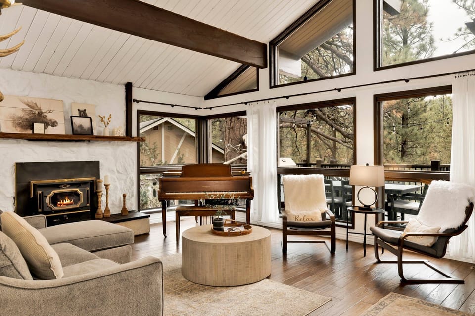 Spacious living room with glowing fireplace, cozy seating, and soft lighting creating a warm retreat