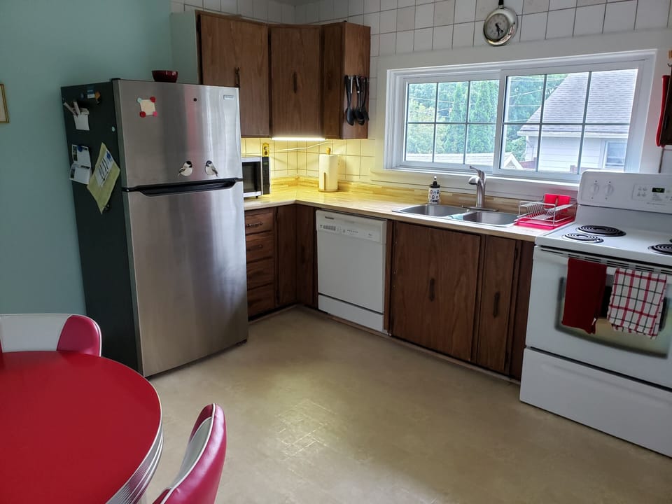 Fully stocked kitchen with fridge, microwave, dishwasher, oven, kettle, keurig